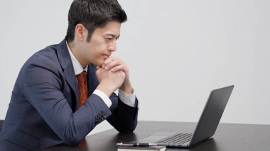 Bilgisayarın önünde endişeli bir işadamı.