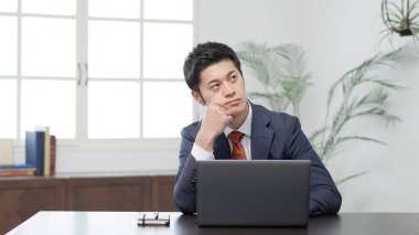 Bilgisayarın önünde endişeli bir işadamı.