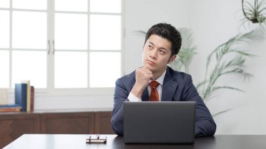 Bilgisayarın önünde endişeli bir işadamı.