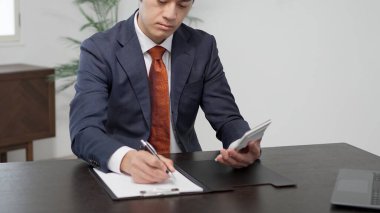 İş adamı hesap makinesiyle bir tahmin hesaplıyor