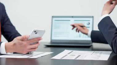 Toplantıda akıllı telefon kullanan bir iş adamının elleri.