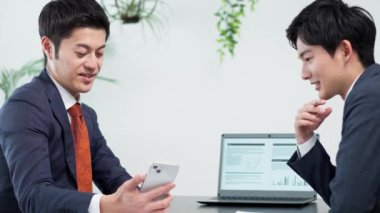 İş adamı toplantıda akıllı telefon kullanıyor.