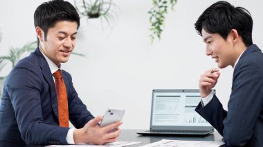 İş adamı toplantıda akıllı telefon kullanıyor.