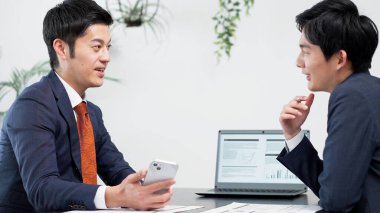 İş adamı toplantıda akıllı telefon kullanıyor.