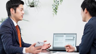 İş adamı toplantıda akıllı telefon kullanıyor.