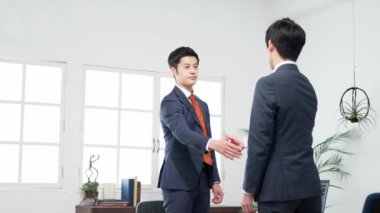 İş adamları toplantıda el sıkışıyor.