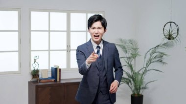 Angry Asian businessman pointing his finger clipart