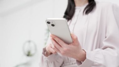 Akıllı telefon kullanan bir kadın eli.