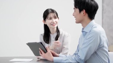 Erkekler ve kadınlar tabletteki belgelere bakıyorlar