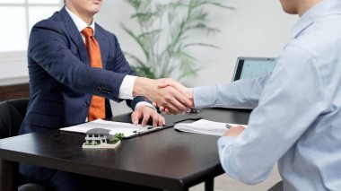 Men shaking hands during a real estate deal clipart