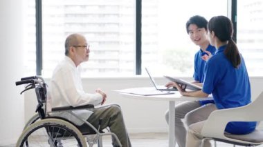 Bir bakıcı yaşlı birine açıklama yapar.