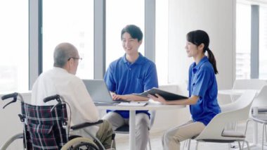 Bir bakıcı yaşlı birine açıklama yapar.