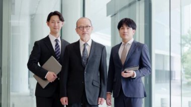 Gülümseyen iş adamı lobide duruyor.