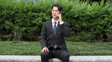 İş adamı dışarıda ciddi bir telefon görüşmesi yapıyor.