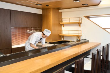 A chef working at a sushi restaurant clipart