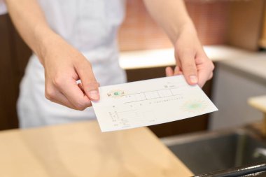 A Japanese chef handing over a receipt clipart