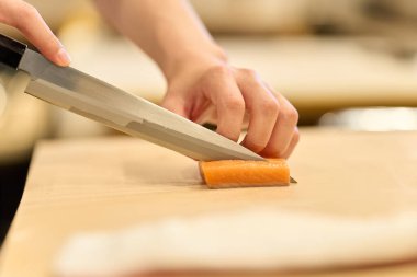 Japon aşçı mutfakta yemek pişiriyor.