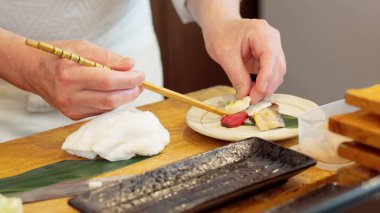 Chef's hands arranging food on a plate clipart