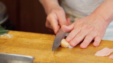 Deniz tarağı kesen bir suşi şefinin elleri.