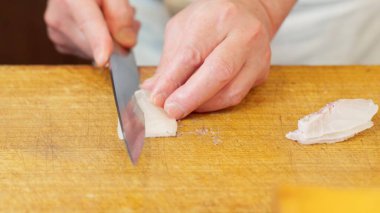 Japon bir şef çipura kesiyor.