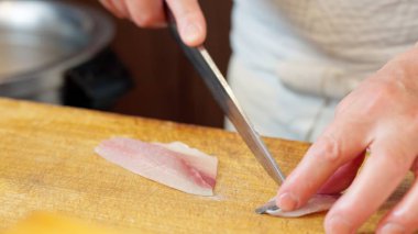 Japon bir şef at uskumrusu kesiyor.