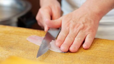 Japon bir şef at uskumrusu kesiyor.