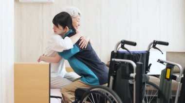 Asian caregiver assisting elderly people with transfers