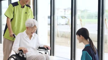 Elderly people and caregivers greeting each other at a nursing home