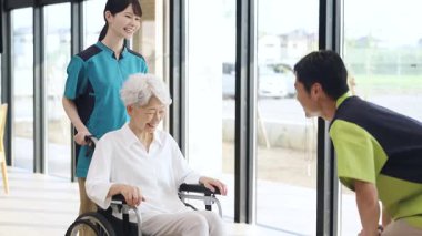 Elderly people and caregivers greeting each other at a nursing home