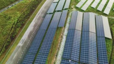 Manzaralı bir alanda güneş paneli kurulumlarının havadan 4K görünümü, sürdürülebilir kalkınma için temiz ve yenilenebilir enerji çözümlerini vurguluyor.