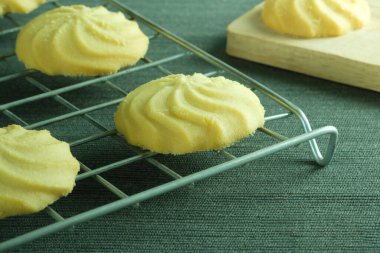 Yakın plan ev yapımı tereyağlı kurabiyeler masanın üzerine ahşap tepsiyle asılmış..