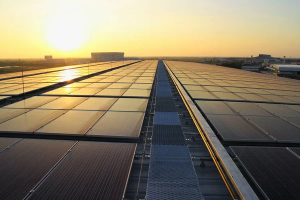日落时分工厂屋顶上的太阳能光伏屋顶 图库图片