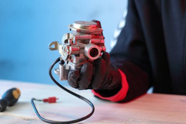 Masadaki dört kulaçlı scooter 'ın eski karbüratörü.