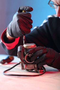 Masadaki dört kulaçlı scooter 'ın eski karbüratörü.