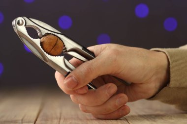 nutcracker in hand over table and colored background