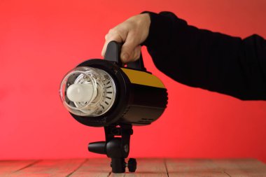 studio flash in a person's hand on a pink background
