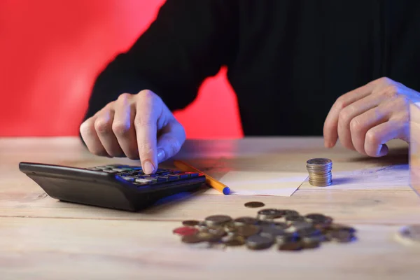 counting on a money calculator by a person on a pink background