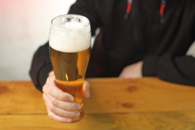 mug with beer in hand on the table and the background of the person