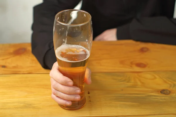 mug with beer in hand on the table and the background of the person