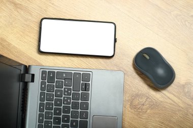 laptop with smartphone and computer mouse on boards from above