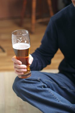 a person holds a mug with beer in his right hand in front of him