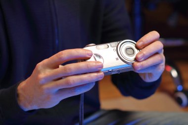 Bir insan eski bir fotoğraf makinesini önünde tutuyor.