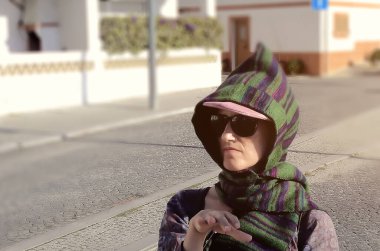 Sokakta başı fularla kaplı bir kadın.