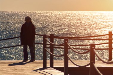 The silhouette of a woman on a pontoon in the sunlight