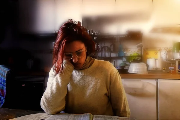 Red-haired woman with glasses reading
