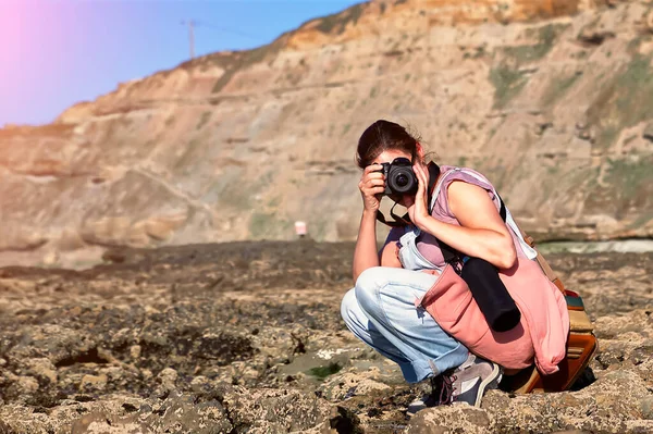 一个女人带着相机在海边拍照 — 图库照片