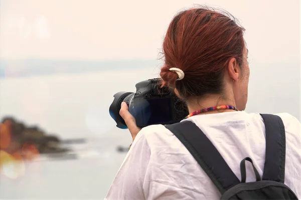 红头发 带着相机和背包在海洋边缘 — 图库照片