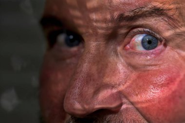 Yüzünde kırışıklıklar olan yaşlı bir adamın portresi.