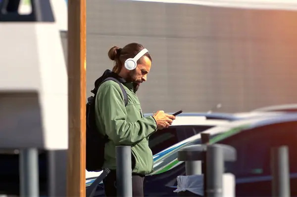 Portrait of a man listening to music with headphones in the street