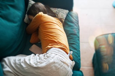 Oturma odasındaki kanepede uyuyan genç bir kadının en iyi görüntüsü.